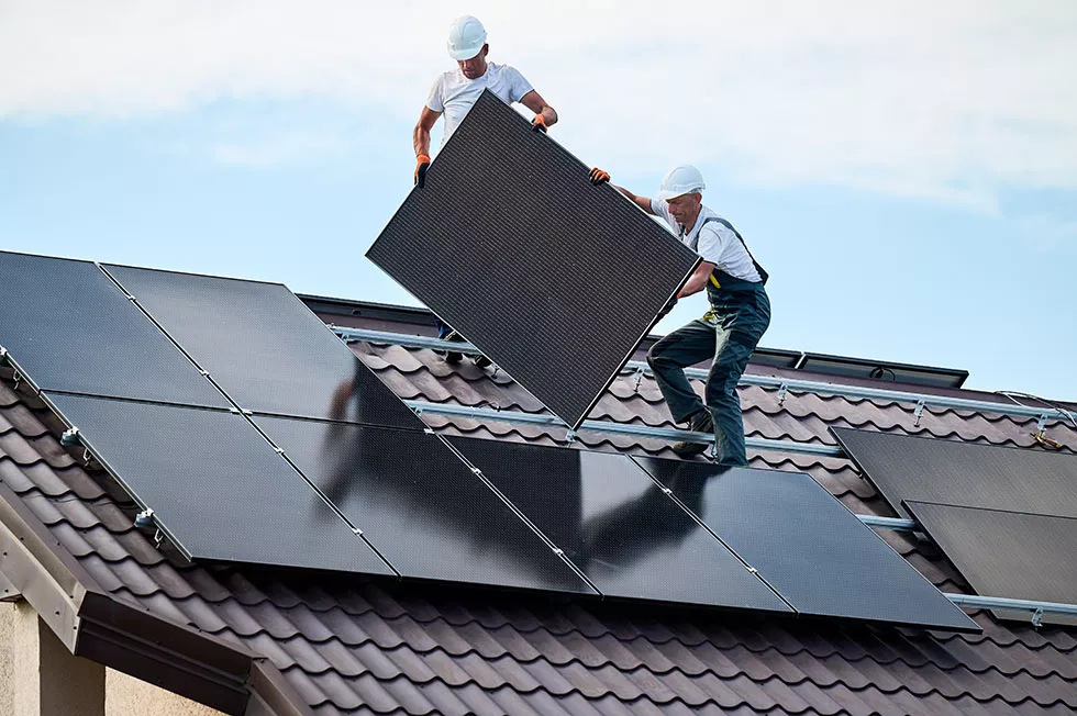 Facharbeiter installieren Solar Panel auf einem Dach zur Erzeugung von Solarstrom